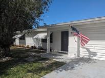 Charming single-story home featuring a well-manicured lawn, crisp white paint, and an American flag at 710 Aqui Esta Dr, Punta Gorda, FL 33950