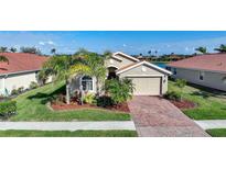 Charming single-Gathering home featuring a brick driveway and a well-manicured lawn with tropical landscaping at 7346 Talon Bay Dr, North Port, FL 34287