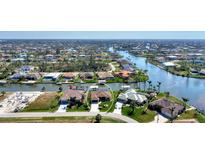 Aerial view of waterfront home with private dock and lush landscaping at 15706 Viscount Cir, Port Charlotte, FL 33981