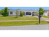 Ranch style home with carport and nicely landscaped lawn at 6064 Deming Ave, North Port, FL 34287