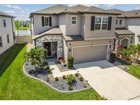 Two-story house with stone accents and landscaped yard at 7537 Pool Compass Loop, Wesley Chapel, FL 33545