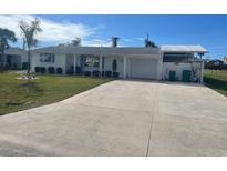 Ranch style home with large driveway and mature landscaping at 105 Crestview Dr, Englewood, FL 34223