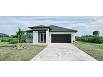 Newly constructed home with a paver driveway and landscaping at 384 Baytree Dr, Rotonda West, FL 33947