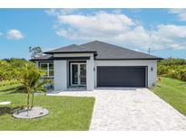 Charming one-story home showcasing a nicely paved driveway and a well-manicured lawn at 384 Baytree Dr, Rotonda West, FL 33947