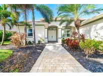 Charming single-story home with a well-manicured lawn, lovely landscaping, and a welcoming front entrance at 65 Par View Ter, Rotonda West, FL 33947