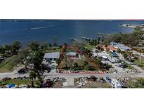 Aerial view of waterfront lot, neighboring houses, and nearby debris at 128 Winson Ave, Englewood, FL 34223