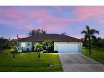 One-story home with a two-car garage and a lush lawn at 13515 Keystone Blvd, Port Charlotte, FL 33981