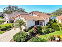 Single-story home with a tile roof, two-car garage, and lush landscaping at 3238 Osprey Ln, Port Charlotte, FL 33953