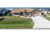 Single-story home with landscaped yard, attached garage, and driveway at 5826 Harrison Rd, Venice, FL 34293