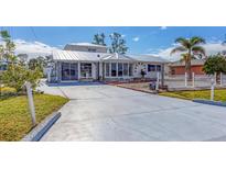 White house with metal roof, long driveway, and fenced yard at 2075 Pennsylvania Ave, Englewood, FL 34224