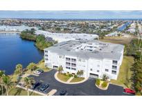 Aerial view of a waterfront condo building with parking and tropical landscaping at 2001 Bal Harbor Blvd # 2203, Punta Gorda, FL 33950
