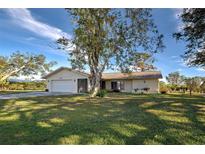 Single-story house with a large yard and mature trees at 1951 Greenlawn Dr, Englewood, FL 34223