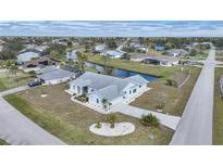 Aerial view of a single-Gathering home with a canal and lush landscaping at 142 Broadmoor Ln, Rotonda West, FL 33947