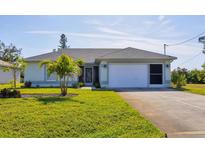 One-story home with attached garage,palm trees, and well-manicured lawn at 185 Cougar Way, Rotonda West, FL 33947