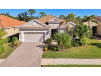 Single-story home with tile roof, landscaped yard, and driveway at 21228 Sandal Foot Dr, Venice, FL 34293