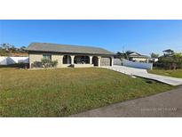 Single-story home with a driveway and landscaped lawn at 23046 Foote Ave, Port Charlotte, FL 33952