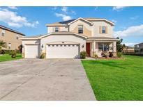 Two-story house with a three-car garage, and a well-manicured lawn at 25676 Prada Dr, Punta Gorda, FL 33955