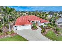 Aerial view of a single-Gathering home with red tile roof and landscaped yard at 26266 Barcelos Ct, Punta Gorda, FL 33983