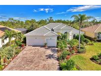 Attractive single-story home with tile roof, paver driveway, and lush landscaping at 2864 Mill Creek Rd, Port Charlotte, FL 33953