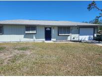 Ranch style home with carport and a spacious lawn at 7330 Regina Dr, Englewood, FL 34224