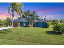 Stunning curb appeal with a modern design, lush lawn, and solar panels at 7510 Kenway St, Englewood, FL 34224