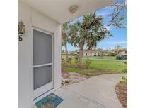 Inviting condo entryway with screen door, showcasing a well-maintained walkway and landscaping at 1 Quails Run Blvd # 5, Englewood, FL 34223