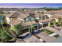 Aerial view of a beautiful townhome community nestled near a lake at 12580 Ghiberti Cir # 101, Venice, FL 34293