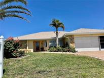 Single-story home with a two-car garage and mature landscaping at 145 Bunker Rd, Rotonda West, FL 33947