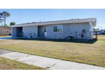 Gray house with stone accents and a landscaped lawn at 22221 Laramore Ave, Port Charlotte, FL 33952