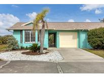 Charming teal home with a one-car garage and nicely landscaped front yard at 255 Boundary Blvd # 105, Rotonda West, FL 33947