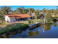 Aerial view of waterfront home with private dock and lush landscaping at 4696 Pompano St, Placida, FL 33946