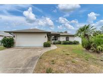 Single-story house with attached garage, landscaping, and a driveway at 11091 Corrigan Ave, Englewood, FL 34224