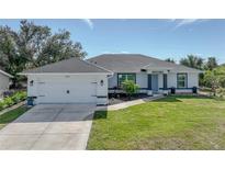 Newly built home with attached garage and well-manicured lawn at 12063 Claremont Dr, Port Charlotte, FL 33981