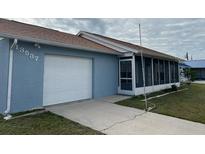 Cute light blue home with a screened porch and one car garage at 13537 Bennett Dr, Port Charlotte, FL 33981