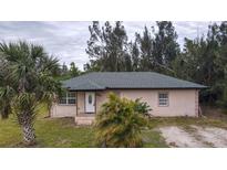 Single-story home with a green roof and landscaping at 15120 Payne St, Punta Gorda, FL 33955