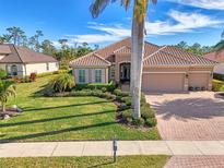 Single-Gathering home with tile roof, landscaped yard, and two-car garage at 2744 Mill Creek Rd, Port Charlotte, FL 33953