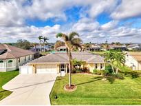 Aerial view of single-Gathering home with a large yard, pool, and canal access at 5231 Conner Ter, Port Charlotte, FL 33981