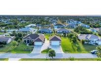 Aerial view of two houses with a large yard and double garages at 7257 Bridgeport Ln, Englewood, FL 34224