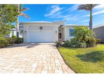 Single-story home with a paver driveway and landscaped front yard at 10479 Coquina Ct, Placida, FL 33946