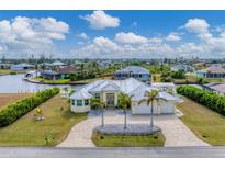 Aerial view of waterfront home with canal access, lush landscaping, and a large backyard at 15228 Chinook Way, Port Charlotte, FL 33981