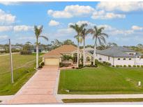 Single-Gathering home with a large yard, palm trees, and a long driveway at 185 Rotonda E Blvd, Rotonda West, FL 33947