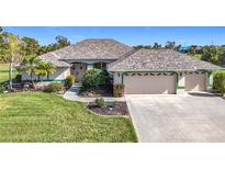 Single-story home with two-car garage, landscaped lawn, and attractive curb appeal at 252 Medalist Rd, Rotonda West, FL 33947