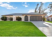 Single story home with a well-manicured lawn and driveway at 4204 Cockrell St, Port Charlotte, FL 33948