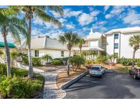 Condo building with palm trees, parking, and a walkway at 5000 Gasparilla Rd # Dc307, Boca Grande, FL 33921