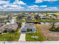 House with gray roof and two car garage is situated on a canal at 60 White Marsh Ln, Rotonda West, FL 33947
