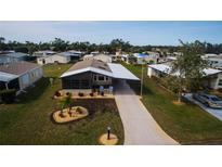 Aerial view of a single-Gathering home with carport and landscaped yard at 808 Tangerine Woods Blvd, Englewood, FL 34223