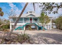 Elevated home with waterfront access, large deck, and a metal roof at 8245 Manasota Key Rd, Englewood, FL 34223