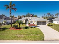 Single-story home with a landscaped yard and two-car garage at 152 Sportsman Rd, Rotonda West, FL 33947