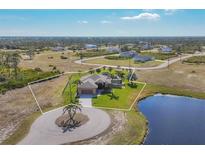 Single-Gathering home with pool and circular driveway, offering a serene waterfront view at 1 Calm Ct, Placida, FL 33946