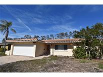 Brick house with a white garage door and a well-maintained lawn at 1755 Georgia Ne Ave, St Petersburg, FL 33703